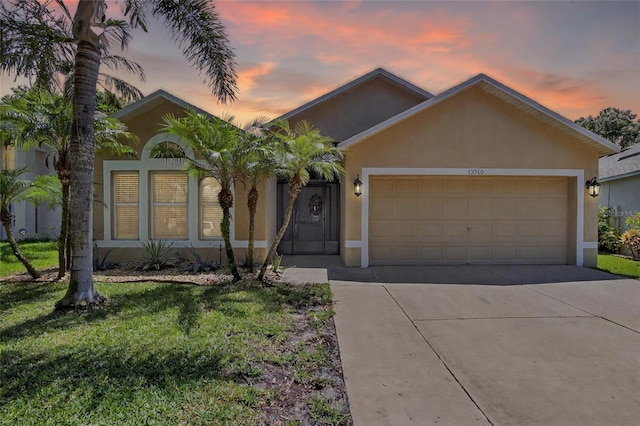 13040 Waterbourne Dr, Gibsonton, FL 33534 - ranch-style home with stucco siding, concrete driveway, a garage, and a front yard