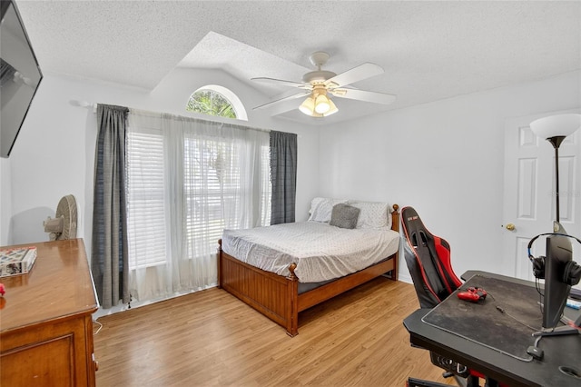 13040 Waterbourne Dr, Gibsonton, FL 33534 - bedroom with lofted ceiling, a desk, light wood-style flooring, a ceiling fan, and a textured ceiling