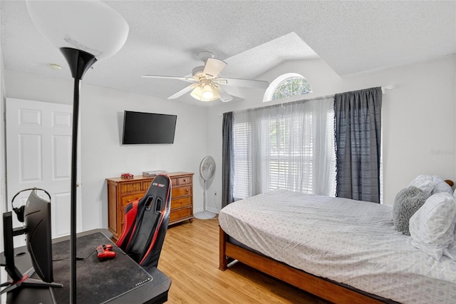 13040 Waterbourne Dr, Gibsonton, FL 33534 - bedroom with lofted ceiling, light wood-style floors, ceiling fan, and a textured ceiling