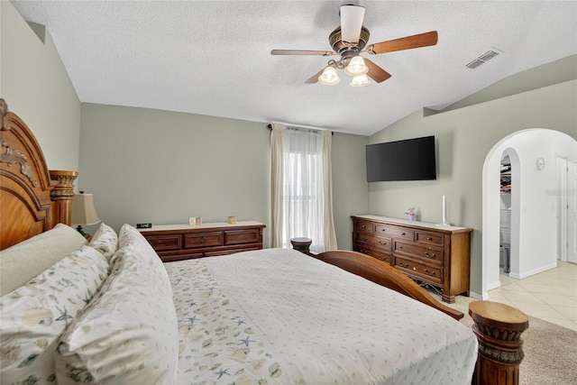 13040 Waterbourne Dr, Gibsonton, FL 33534 - bedroom with arched walkways, lofted ceiling, a textured ceiling, ceiling fan, and light tile patterned floors
