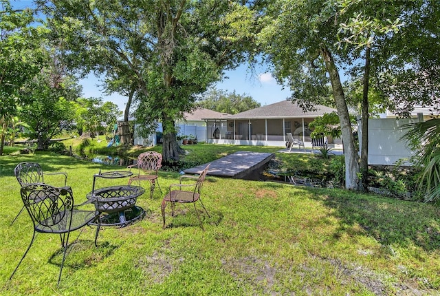 13040 Waterbourne Dr, Gibsonton, FL 33534 - view of green lawn with an outdoor fire pit, a sunroom, and a playground