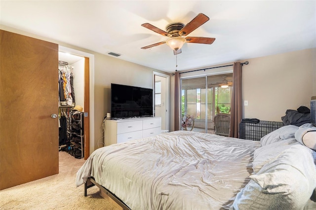 7510 Tyson Dr, Port Richey, FL 34668 - bedroom with access to exterior, a walk in closet, light colored carpet, and a ceiling fan