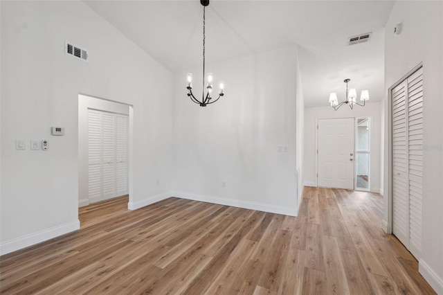 4236 Woodtrail Blvd, New Port Richey, FL 34653 - unfurnished dining area with a chandelier, light wood-type flooring, and high vaulted ceiling