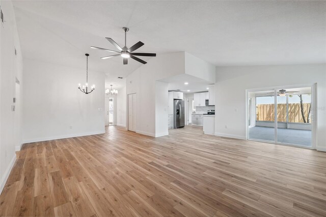 4236 Woodtrail Blvd, New Port Richey, FL 34653 - unfurnished living room with a chandelier, a ceiling fan, light wood-style floors, and high vaulted ceiling