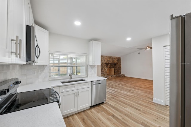 4236 Woodtrail Blvd, New Port Richey, FL 34653 - kitchen featuring stainless steel appliances, a stone fireplace, open floor plan, white cabinets, and recessed lighting