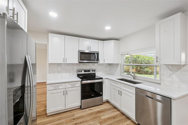 4236 Woodtrail Blvd, New Port Richey, FL 34653 - kitchen featuring stainless steel appliances, light wood finished floors, white cabinetry, light countertops, and recessed lighting