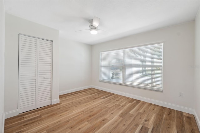 4236 Woodtrail Blvd, New Port Richey, FL 34653 - unfurnished bedroom with a closet, light wood-style flooring, and a ceiling fan