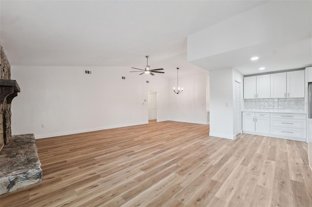 4236 Woodtrail Blvd, New Port Richey, FL 34653 - unfurnished living room featuring a ceiling fan, a fireplace, light wood-style flooring, a chandelier, and recessed lighting