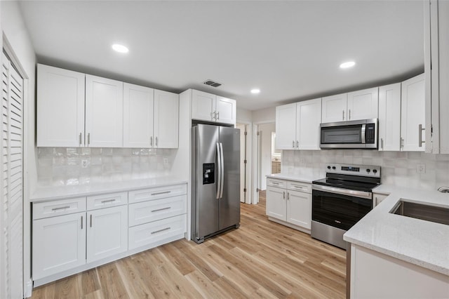 4236 Woodtrail Blvd, New Port Richey, FL 34653 - kitchen featuring stainless steel appliances, white cabinets, decorative backsplash, and recessed lighting