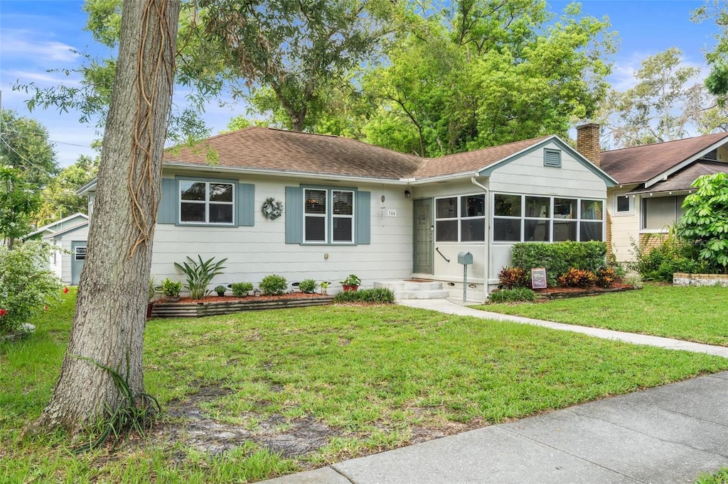 744 25th Ave N, Saint Petersburg, FL 33704 - ranch-style house featuring a front lawn, a shingled roof, and a chimney