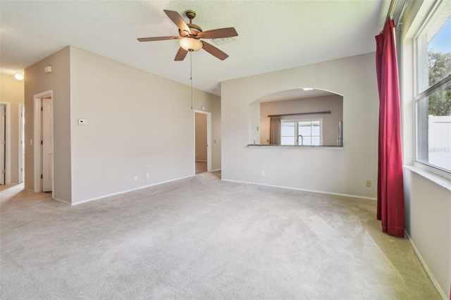 501 Royal Ridge St, Valrico, FL 33594 - spare room featuring a ceiling fan, light colored carpet, plenty of natural light, arched walkways, and a textured ceiling