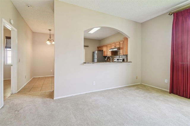 501 Royal Ridge St, Valrico, FL 33594 - unfurnished living room featuring carpet flooring, arched walkways, a chandelier, and tile patterned floors