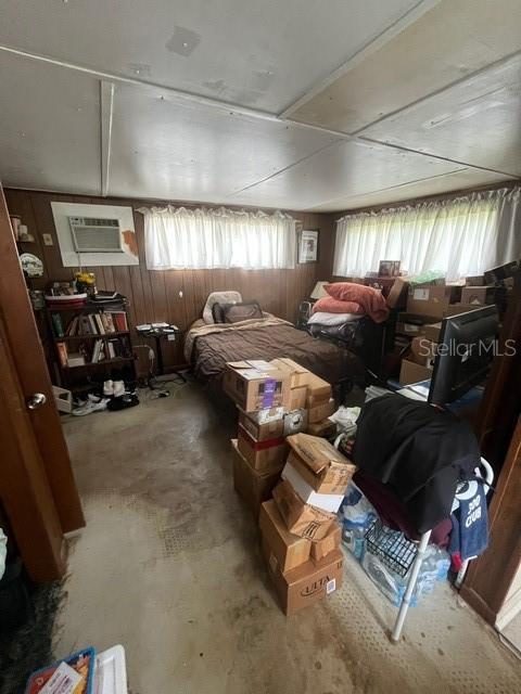 8946 Dream Way, Largo, FL 33773 - bedroom featuring a wall mounted AC and unfinished concrete floors
