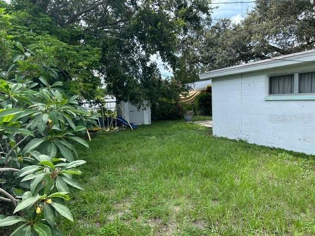 8946 Dream Way, Largo, FL 33773 - view of grassy yard featuring a storage shed