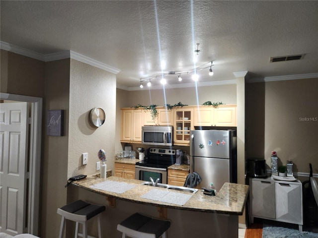 3713 Conroy Rd Unit 1922, Orlando, FL 32839 - kitchen featuring appliances with stainless steel finishes, crown molding, a kitchen breakfast bar, a peninsula, and glass insert cabinets
