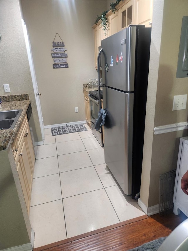 3713 Conroy Rd Unit 1922, Orlando, FL 32839 - kitchen featuring appliances with stainless steel finishes, dark stone counters, light tile patterned flooring, and cream cabinets