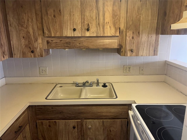 6125 Chesham Dr Unit 1, New Port Richey, FL 34653 - kitchen with light countertops, tasteful backsplash, ventilation hood, and brown cabinets
