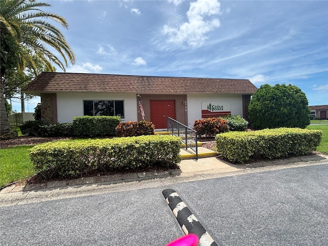 6125 Chesham Dr Unit 1, New Port Richey, FL 34653 - view of front of house with stucco siding and a shingled roof
