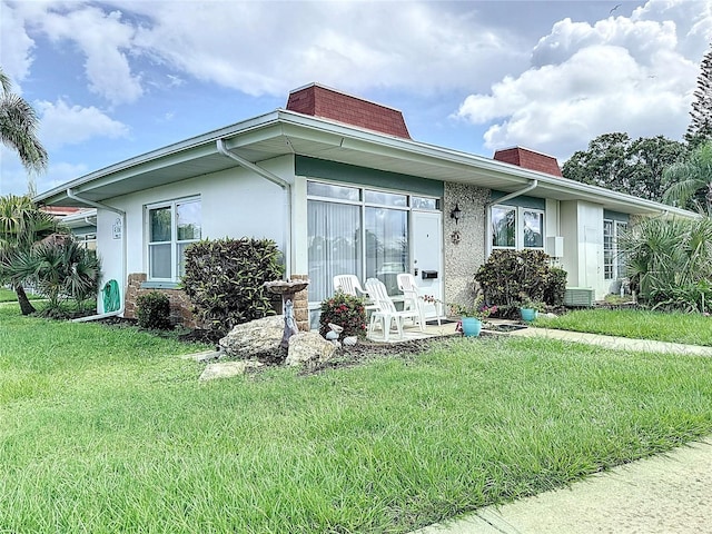 4360 Tahitian Gardens Cir Unit H, Holiday, FL 34691 - view of front facade featuring a chimney, a front yard, and stucco siding