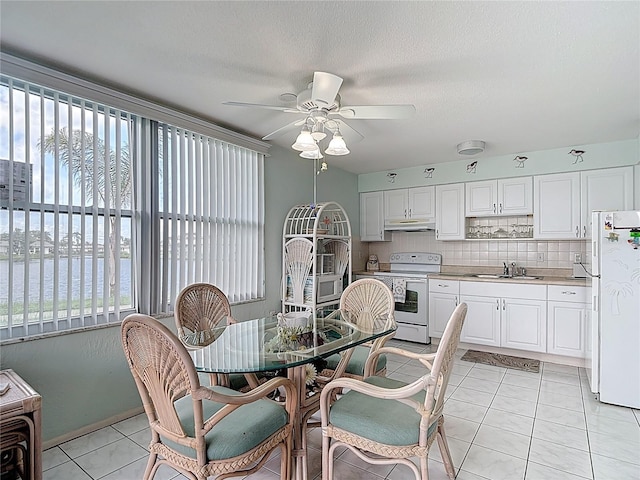 4360 Tahitian Gardens Cir Unit H, Holiday, FL 34691 - dining space with a ceiling fan, light tile patterned floors, a water view, and a textured ceiling