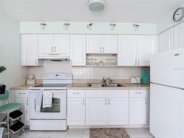 4360 Tahitian Gardens Cir Unit H, Holiday, FL 34691 - kitchen with white appliances, under cabinet range hood, white cabinets, and backsplash