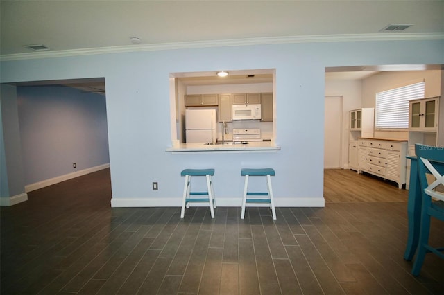 3643 Mainlands Blvd N, Pinellas Park, FL 33782 - kitchen featuring white appliances, dark wood-style flooring, ornamental molding, and a breakfast bar