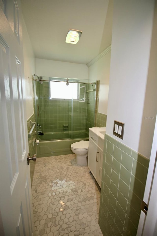 3643 Mainlands Blvd N, Pinellas Park, FL 33782 - bathroom with vanity, enclosed tub / shower combo, tile walls, a wainscoted wall, and tile patterned flooring