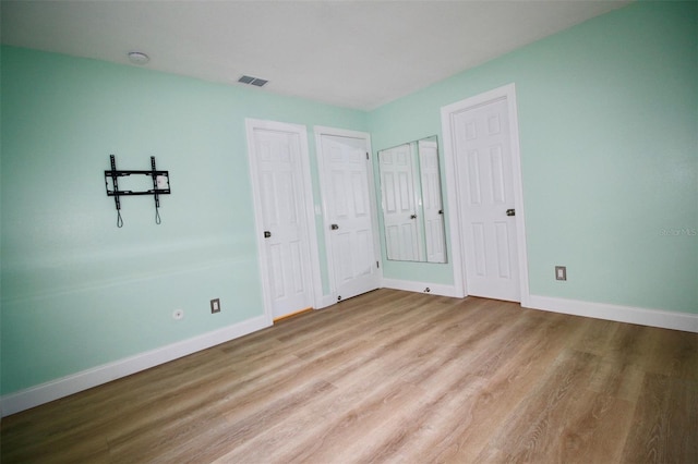 3643 Mainlands Blvd N, Pinellas Park, FL 33782 - unfurnished bedroom with wood finished floors and multiple closets