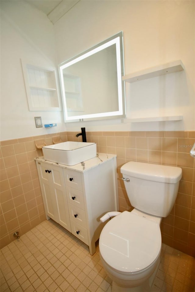 3643 Mainlands Blvd N, Pinellas Park, FL 33782 - bathroom featuring tile walls, vanity, tile patterned floors, and wainscoting