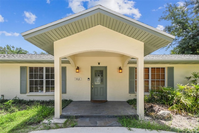 4514 John Moore Rd, Brandon, FL 33511 - doorway to property featuring stucco siding and roof with shingles