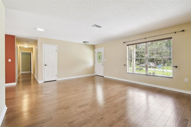 4514 John Moore Rd, Brandon, FL 33511 - unfurnished living room featuring a textured ceiling and light wood-type flooring