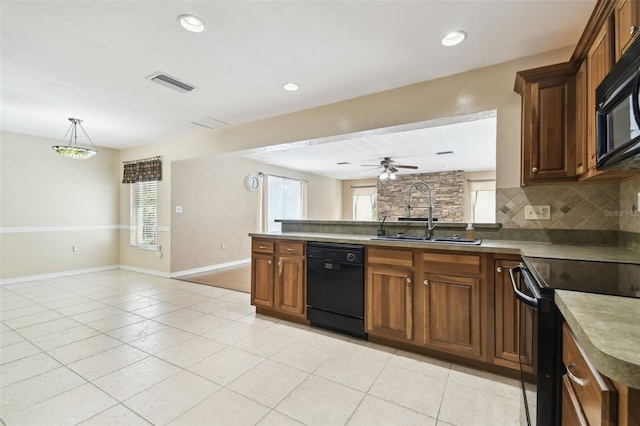 4514 John Moore Rd, Brandon, FL 33511 - kitchen featuring black appliances, light tile patterned floors, a peninsula, healthy amount of natural light, and recessed lighting