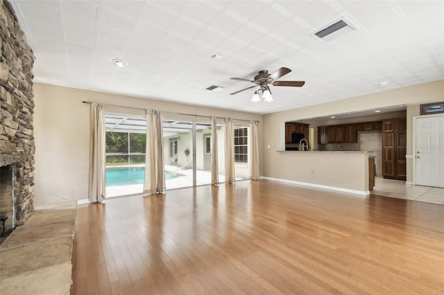 4514 John Moore Rd, Brandon, FL 33511 - unfurnished living room featuring light wood-style flooring, ceiling fan, and a fireplace