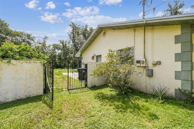 4514 John Moore Rd, Brandon, FL 33511 - view of property exterior featuring stucco siding, a gate, and a yard