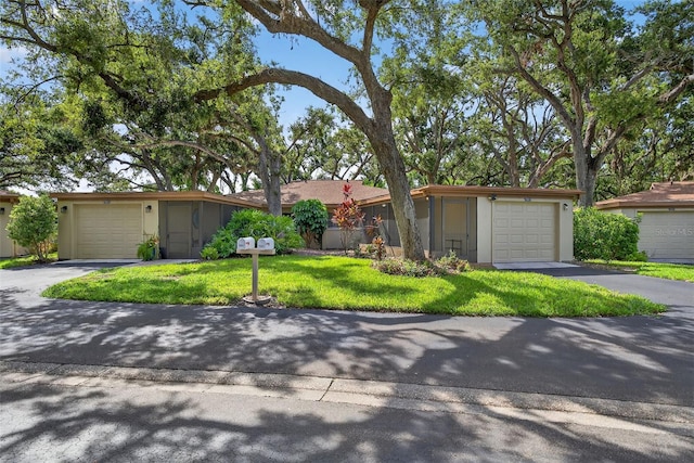 7051 Bright Creek Dr Unit 6, Sarasota, FL 34231 - view of front facade with stucco siding, a front lawn, and asphalt driveway