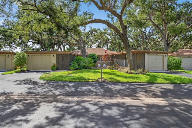7051 Bright Creek Dr Unit 6, Sarasota, FL 34231 - view of front of home featuring stucco siding, asphalt driveway, a front yard, and an attached garage