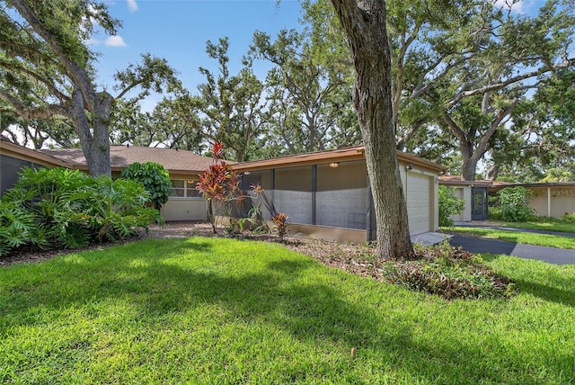 7051 Bright Creek Dr Unit 6, Sarasota, FL 34231 - view of front of house featuring a front lawn, asphalt driveway, an attached garage, and a sunroom