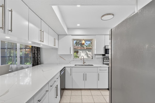 7051 Bright Creek Dr Unit 6, Sarasota, FL 34231 - kitchen with appliances with stainless steel finishes, white cabinets, light tile patterned floors, light stone counters, and recessed lighting