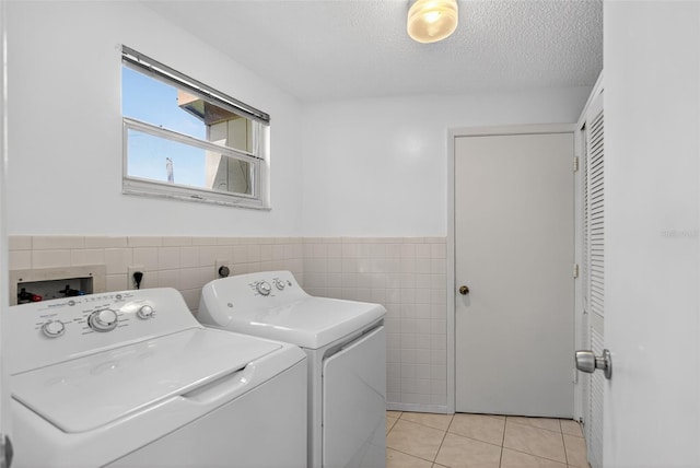 7051 Bright Creek Dr Unit 6, Sarasota, FL 34231 - laundry room with tile walls, washing machine and clothes dryer, light tile patterned floors, wainscoting, and a textured ceiling