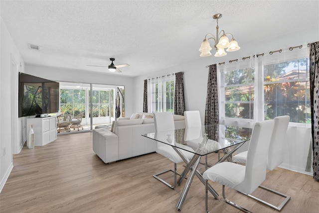 7051 Bright Creek Dr Unit 6, Sarasota, FL 34231 - dining room featuring a textured ceiling, a chandelier, light wood-style floors, and ceiling fan