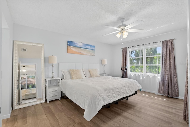 7051 Bright Creek Dr Unit 6, Sarasota, FL 34231 - bedroom with light wood-style flooring, a textured ceiling, and ceiling fan