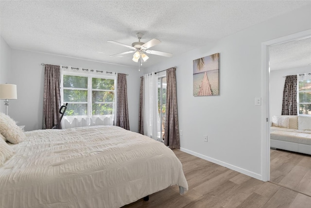 7051 Bright Creek Dr Unit 6, Sarasota, FL 34231 - bedroom featuring multiple windows, wood finished floors, a textured ceiling, and ceiling fan