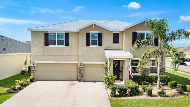 15206 Trinity Fall Way, Bradenton, FL 34212 - view of front facade featuring stucco siding, driveway, a garage, and roof with shingles