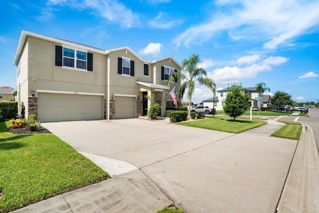 15206 Trinity Fall Way, Bradenton, FL 34212 - view of front of home featuring a garage, stucco siding, driveway, stone siding, and a front yard