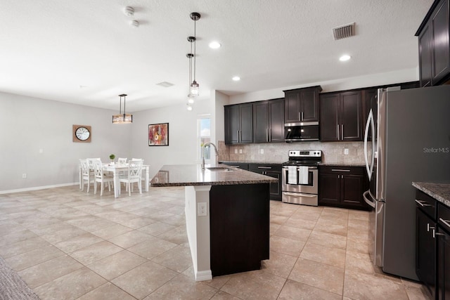 15206 Trinity Fall Way, Bradenton, FL 34212 - kitchen featuring appliances with stainless steel finishes, backsplash, dark stone countertops, recessed lighting, and light tile patterned flooring