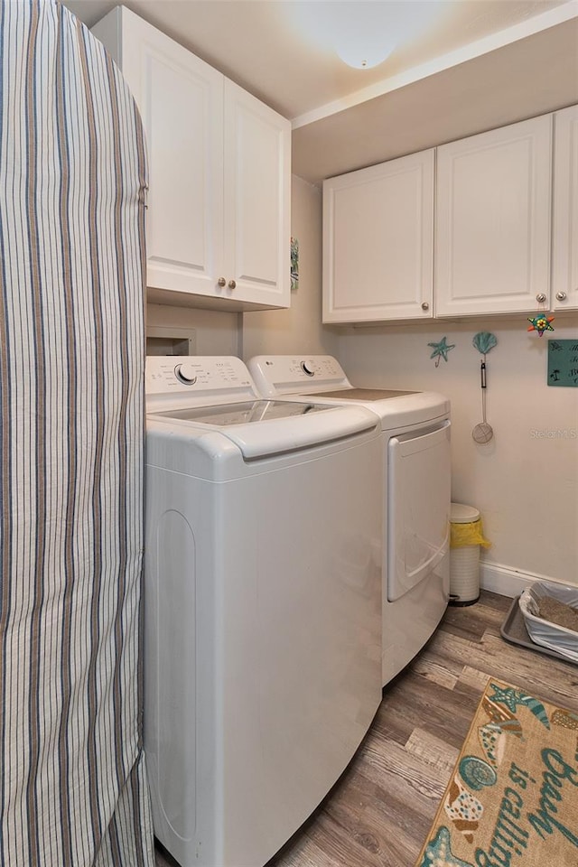 700 Starkey Rd Unit 1124, Largo, FL 33771 - laundry room featuring cabinet space, light wood finished floors, and independent washer and dryer