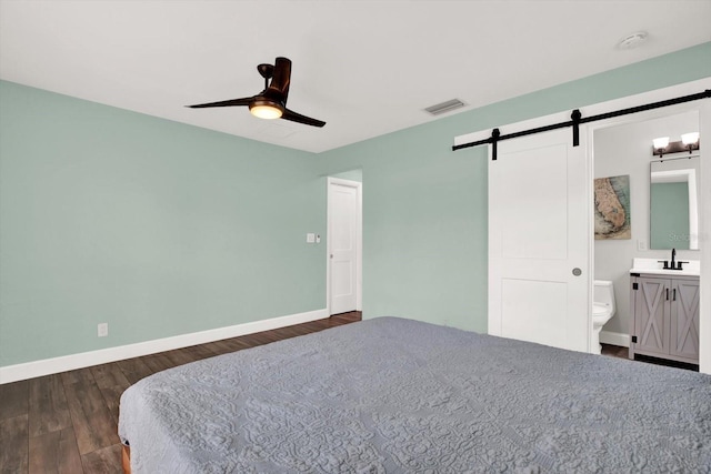 6000 115th Ln, Seminole, FL 33772 - bedroom with a barn door, dark wood finished floors, ensuite bathroom, and ceiling fan