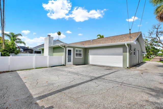 6000 115th Ln, Seminole, FL 33772 - rear view of property with an attached garage, stucco siding, driveway, and roof with shingles