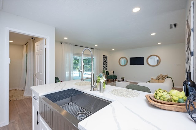 4504 Grainary Ave, Tampa, FL 33624 - kitchen with recessed lighting, light wood finished floors, light stone countertops, and white cabinetry