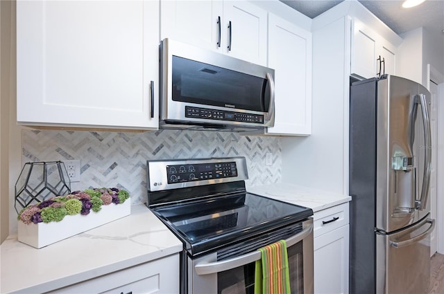 4504 Grainary Ave, Tampa, FL 33624 - kitchen featuring appliances with stainless steel finishes, white cabinets, and tasteful backsplash